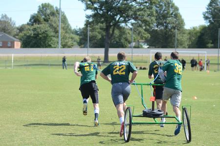 Members of the fraternity Sigma Alpha Epsilon race against Lambda Chi Alpha and Alpha Tau Omega during the chariot race at Greek Olympics. - Photo by Emily Stookey