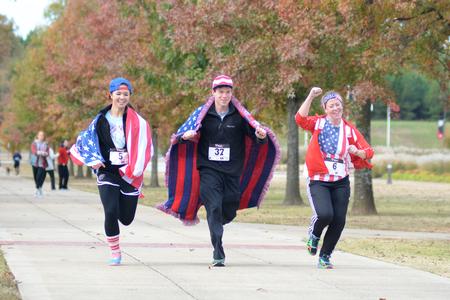 Morgan Morfe, junior social work major, Ben Melton, sophomore biology major, and Miracle Burton, sophomore nursing major, finish the Make-a-Wish 5K in their American-themed outfits. - Photo by Meg Rushing