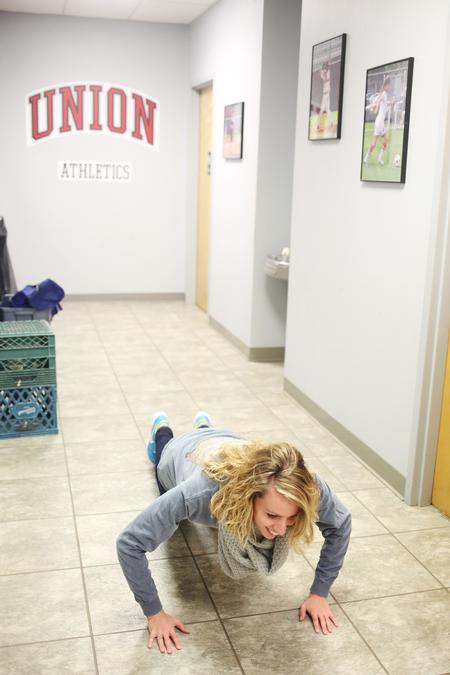 Kaylene Portell, junior social work major, does 10 burpees as part of a challenge in res-life's Amazing Race game. - Photo by Kristi McMurry Woody
