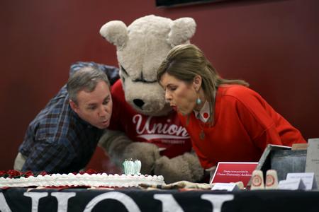 Dub and Susie Oliver, president and first lady of the university, join Buster the Bulldog in blowing out the candles on Union's 192nd birthday cake in Brewer Dining Hall. - Photo by Amanda Rohde