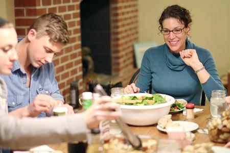 Kayla McKinney, residence director in Heritage, spends time with a group of students in her colleague's apartment during Be Our Guest, an event where students enjoy a home cooked meal with faculty and staff members.  - Photo by Kristi McMurry Woody