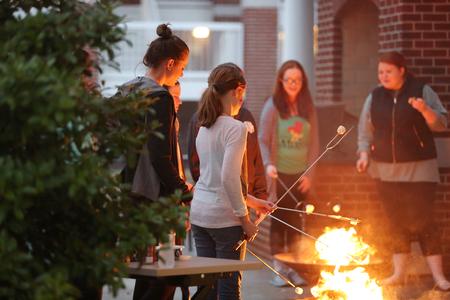Kristen Witham, senior art major, roasts marshmallows with her sisters during Residence Life's Sibling Weekend event on the Bowld Commons patio. - Photo by Kristi McMurry Woody