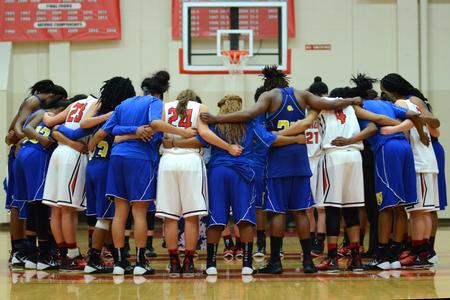 The Union University women's basketball team prays together with the opposing team after a Union tournament game win. - Photo by Meg Rushing