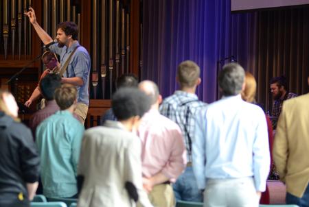 Nathan Shoemaker, junior music major, leads the congregation in worship during the GO Trip Report chapel service. - Photo by MiKalla Cotton