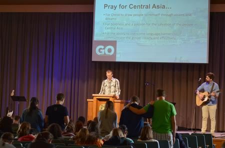 Joshua Edgren, junior physics major and leader of the Central Asia GO Trip last summer, prays over the Central Asia GO Trip team for this upcoming summer during the Go Trip Report chapel service. - Photo by MiKalla Cotton