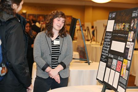 Katie Williams, senior art major, talks to guests of the Scholarship Symposium about her research on hand-lettering in graphic design. Williams uses this design process in her own excellent work. - Photo by Kristi McMurry Woody
