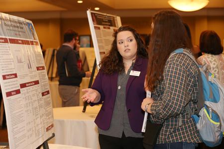 Amanda Davidson, Master of Science in Nursing
Administration student, explains her poster research at the annual Scholarship Symposium poster presentations. - Photo by Kristi McMurry Woody