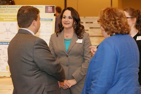 Phyllis Moore, doctor of nursing practice student, discusses her research work at the annual Scholarship Symposium poster sessions. - Photo by Kristi McMurry Woody