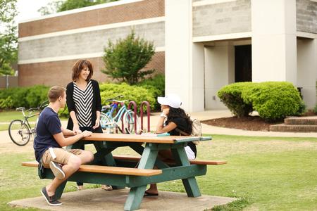 Chris Bailey, assistant professor of English and director of composition support, talks with students outside the Student Union Building. - Photo by Kristi McMurry Woody