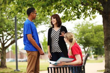 Chris Bailey, assistant professor of English and director of composition support, chats with some students outside. - Photo by Kristi McMurry Woody