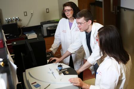 Sally Henrie, professor of chemistry, works with a couple of students in the lab. - Photo by Kristi McMurry Woody