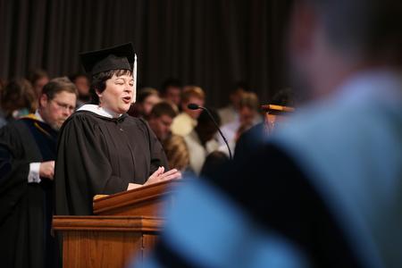 Ashley Blair, assistant professor of communication arts and faculty member of the year, prays at the start of Convocation. - Photo by Kristi McMurry Woody