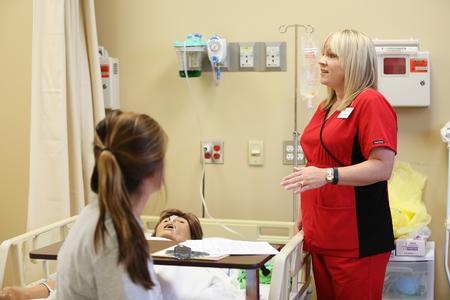 Jennifer Delk, assistant professor of nursing, introduces MSN students to the equipment they'll be using in the Skills Lab in Providence Hall.  - Photo by Kristi McMurry Woody