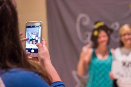 Friends pose for a cell phone picture at the Chi Omega Make-A-Wish Barbecue during Family Weekend. - Photo by David Parks