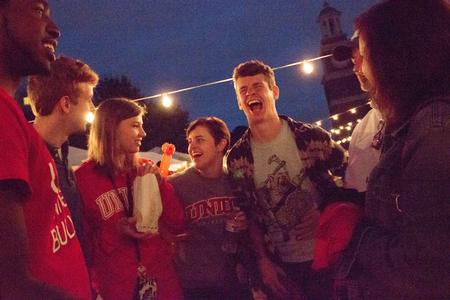 High school senior David Bowman laughs alongside his family at Union Night during Family Weekend. - Photo by David Parks
