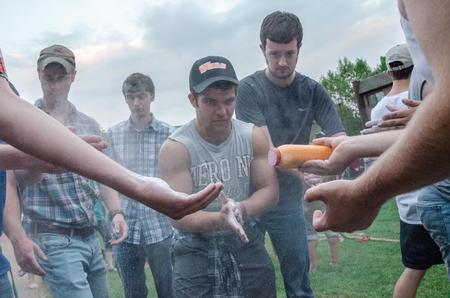 Alex Herman, freshman cell and molecular biology major, applies powder alongside his Dodd comrades before the tug-of-war.  - Photo by David Parks