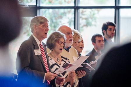 Alumni and other members of the audience sing "Alma Mater" during homecoming chapel. - Photo by David Parks