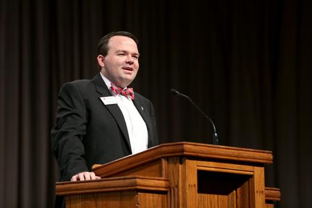 Josh Clarke, director of alumni and annual fund, welcomes guests to Homecoming chapel. - Photo by Kristi McMurry Woody