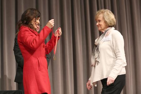 Susie Oliver, first lady of the university, prepares to give Linda Stewart, class of 1966, her 50 year medallion during Homecoming chapel. - Photo by Kristi McMurry Woody