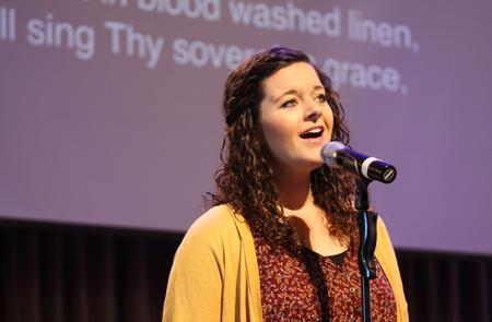 Kayla McKinney, resident director of the women's quads, leads music in chapel. - Photo by Sol Bee Park