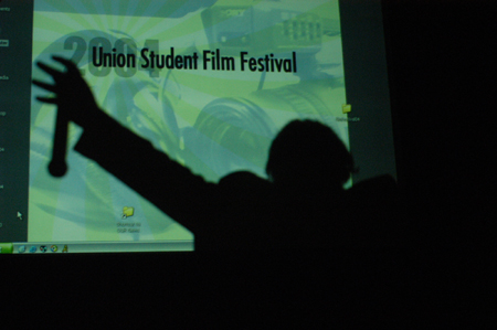 The dreadlocked Jonathan Blair hosted the 2004 Student Film Festival.  This second year of the film festival saw twelve films compete for awards in technical, acting and trivial categories.  The Students' Choice Award was presented to junior James Berger for <i>Dust and Ashes</i> and the Jury's Award for long form films was awarded to Trae Cadenhead for <i>Within a Room Somewhere</i>. - Photo by Kristen Nicole Sayres