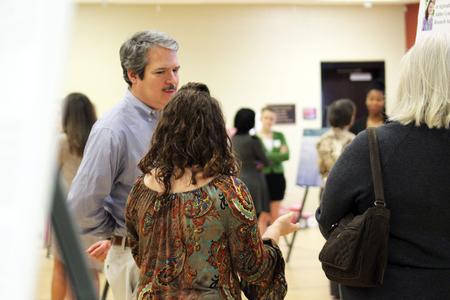 William Thierfelder, associate professor of biology, listens as a student explains her research during Fall Poster Sessions. - Photo by Sol Bee Park