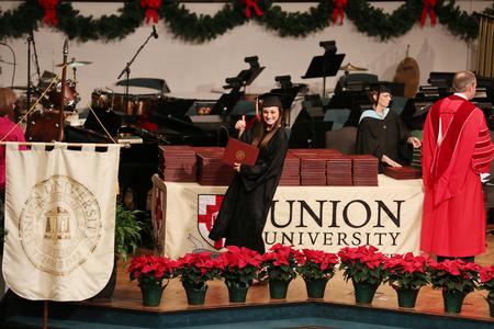 A student celebrates after receiving her diploma during fall commencement services. - Photo by Kristi McMurry Woody