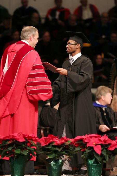 Terrance Murphy, Biblical studies graduate, accepts his diploma from Dub Oliver, president of the university, during fall commencement services.  - Photo by Kristi McMurry Woody