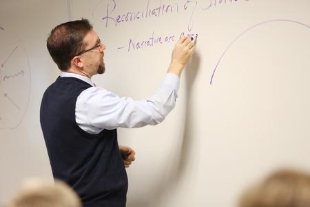 Justin Barnard, associate professor of philosophy, writes notes on the board for his class.  - Photo by Kristi McMurry Woody