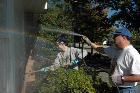 Senior Adam Winters & math professor Byran Dawson wash shutters and windows at Birth Choice during Day of Remembrance. - Photo by Amanda Herron