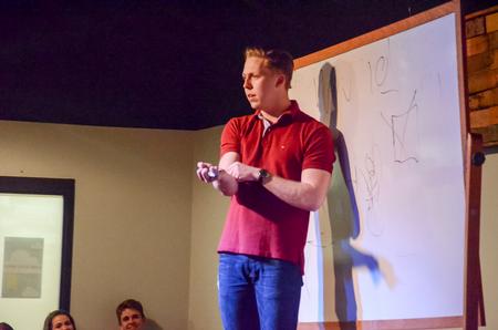 Garyn McIntyre, senior French major, teaches scholars how to be "manly men" at Blank State Improv's show in Barefoots Joe. - Photo by Gretchen Foels