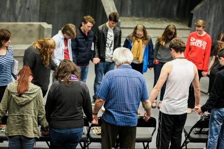 David Burke, director of the W.D. Powell Theatre, prays with the cast and crew of The Queen and the Rebels before starting practice.  - Photo by Kristi McMurry Woody