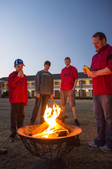 Ken Litscher, director of Residence Life (on right), lights a fire to warm up the Residence Life Grill Out for Sibling Weekend. - Photo by David Parks