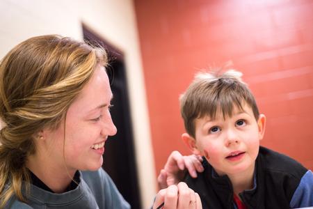 Brittney Schlatter, Resident Advisor and junior nursing major, paints faces during the Residence Life Grill Out event for Sibling Weekend. - Photo by David Parks