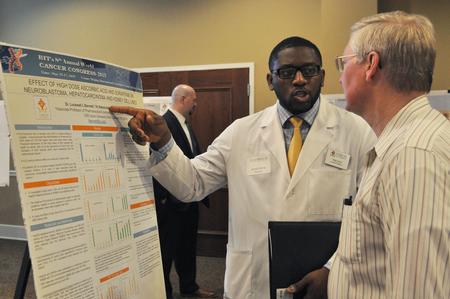 During the Scholarship Symposium in the Carl Grant Event Center, Rene Effoe, doctor of pharmacy, shares his presentation poster. - Photo by Elizabeth Wilson