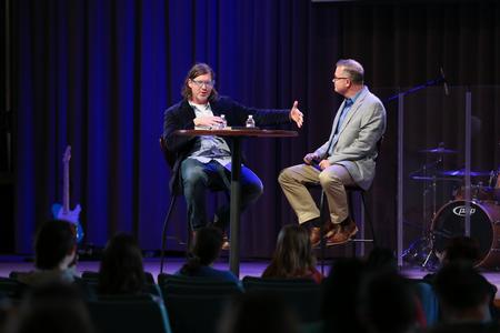 Ted Kluck, assistant professor of communication arts, answers questions posed by Todd Brady, vice president for university ministries, during an interview style chapel service.  - Photo by Kristi McMurry Woody