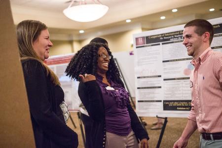 Student nurses Rachel Horton and Mary Joseph laugh with Daniel Watkins (on right), senior nursing major, during the Scholarship Symposium poster presentations in the Carl Grant Events Center. - Photo by David Parks