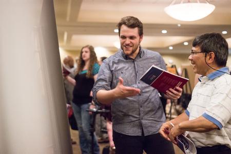 Thomas Griffith, senior art major, talks about his project with Don Van, professor of engineering, during the Scholarship Symposium poster presentations in the Carl Grant Events Center. - Photo by David Parks