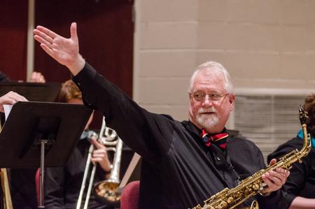 David McClune, professor of music, directs the crowd's cheering to his band after the last piece fades out. - Photo by David Parks