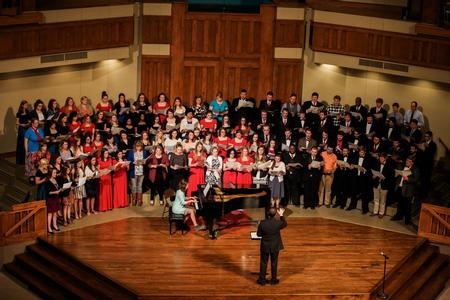 Alumni from the past decade joined the University Singers on stage at the end of the spring choral concert. The group performed an arrangement of Be Thou My Vision as a gift to Chris Mathews, who will be transitioning to another university after the semester ends. - Photo by Kristi McMurry Woody