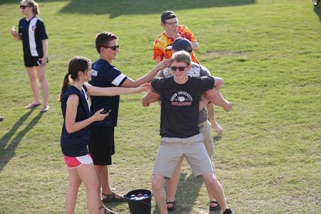 Students competing in the Res Life Field Day events try to carry a water balloon between their backs without popping it.  - Photo by Kristi McMurry Woody