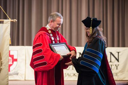 Dub Oliver, president of the university, presents Colleen Trent, assistant professor of economics, with the Howard Newell Innovative Teaching Award during Awards Day. - Photo by Kristi McMurry Woody