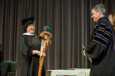 Ashley Blair, 2014-2015 Faculty Member of the Year, hands the mace off to Web Drake during Awards Day Chapel. - Photo by Kristi McMurry Woody
