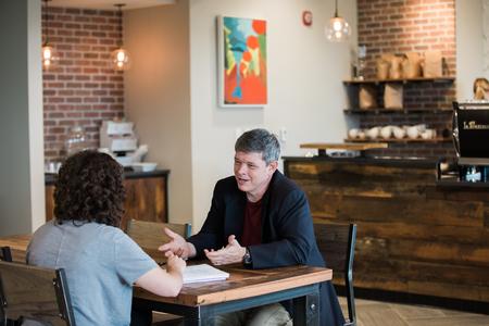 Web Drake, associate professor of communication arts and faculty member of the year, chats with Kaylee Gibson, junior public relations major, in Modero. - Photo by Kristi McMurry Woody