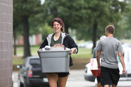 Emily Johnson, junior biology major, helps a new student move things into the residence complexes during new student move-in day. - Photo by Kristi McMurry Woody