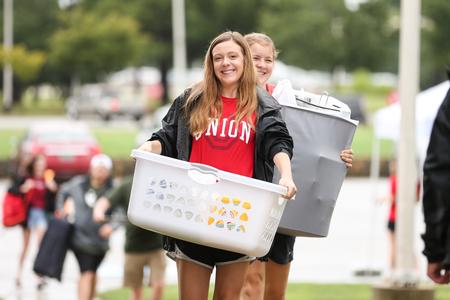 Adrian Lamp, sophomore nursing major, helps carry items into the Heritage Complex during new student move-in day. - Photo by Kristi McMurry Woody