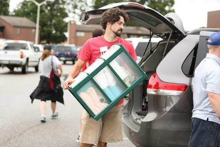 Scott Heit, assistant vice president for university communications, helps unload a vehicle for a new student moving in. - Photo by Kristi McMurry Woody