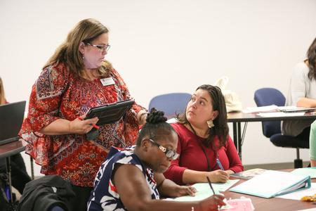 Nancy Cherry, professor of education and director of master's programs in education, works with students during a literacy class in the graduate program. - Photo by Kristi McMurry Woody