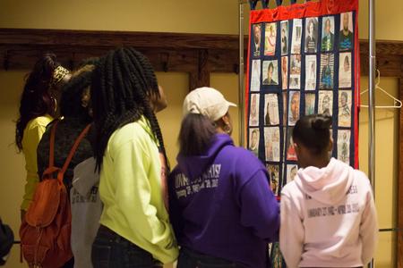 Guests at the Remember Me Walk look at the memorial quilt made with photos of loved ones lost to homicide. - Photo by Kristi McMurry Woody