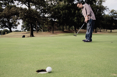 Junior Nathan Morris, Christian ethics major,
watches intently as the ball curves inward on the green. - Photo by Kathleen Murray